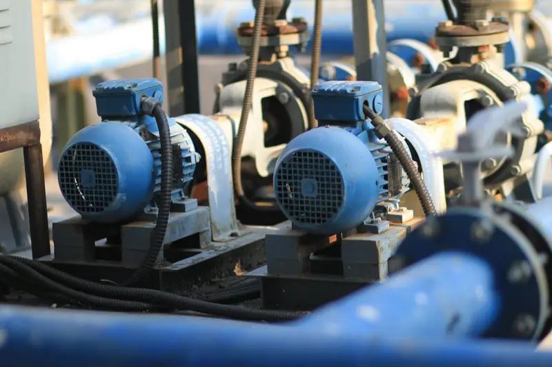 Row of blue centrifugal pumps on a plant floor